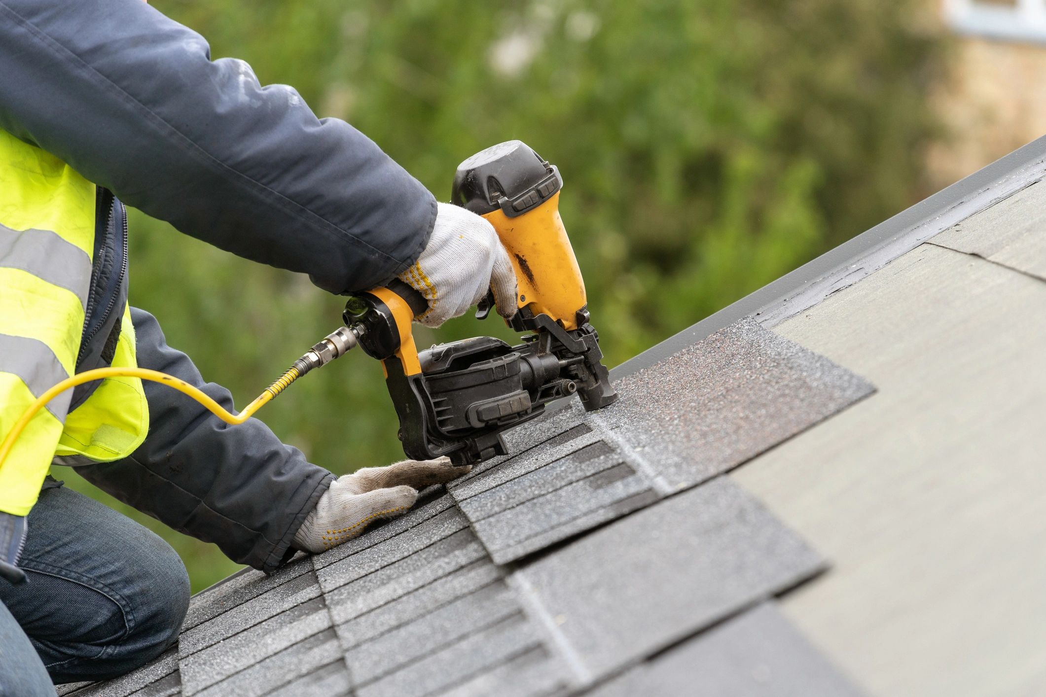 Unrecognizable roofer worker in uniform work wear using.