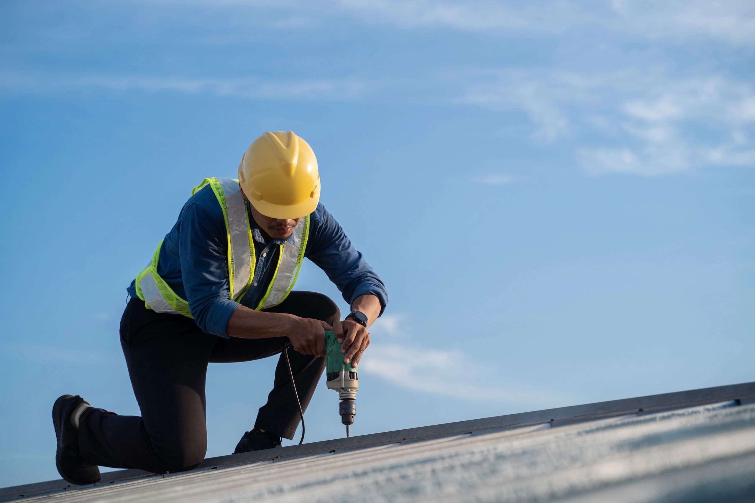 Aerial view in worker hands installing bitumen roof.