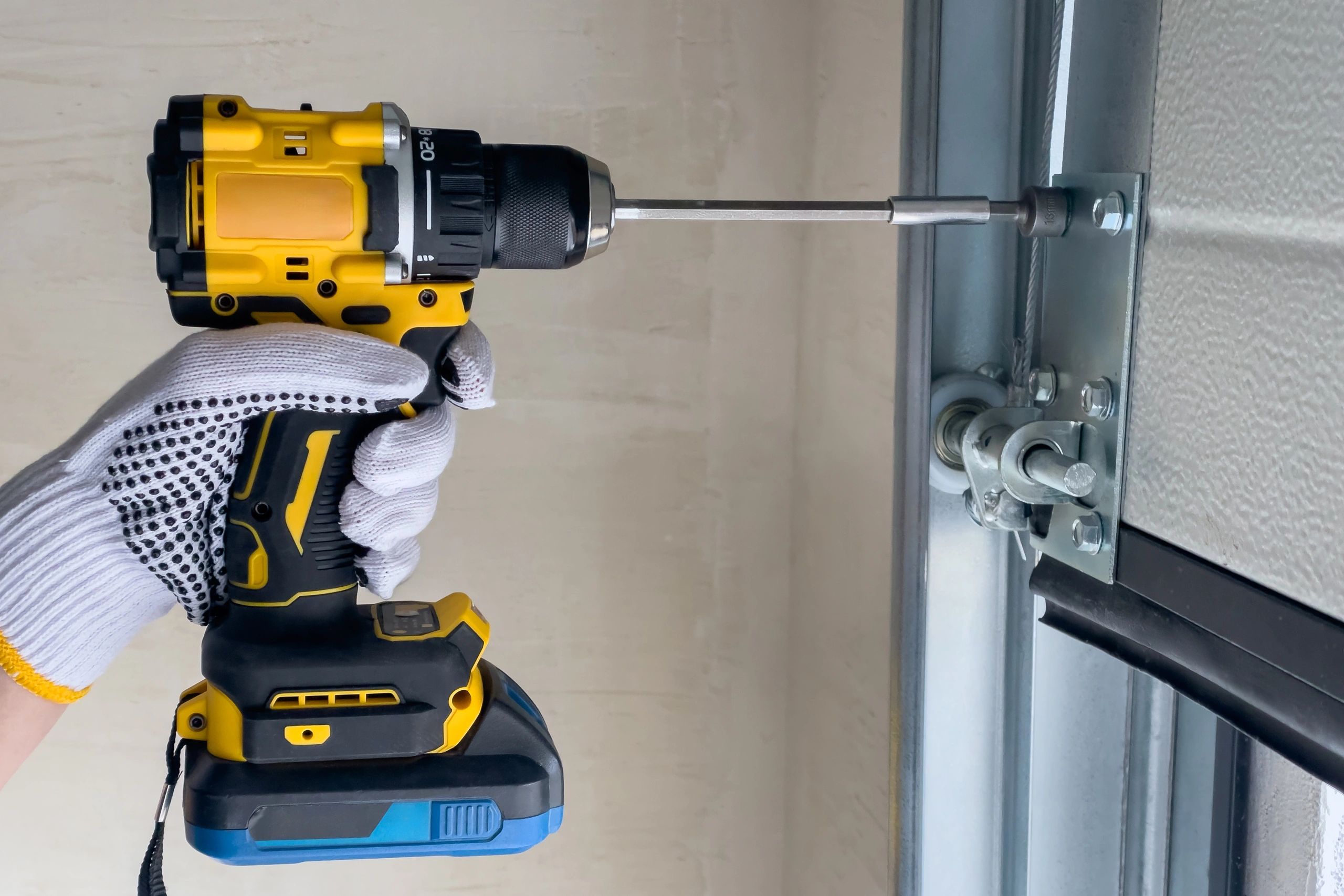 A craftsman assembles sectional doors using a screwdriver.